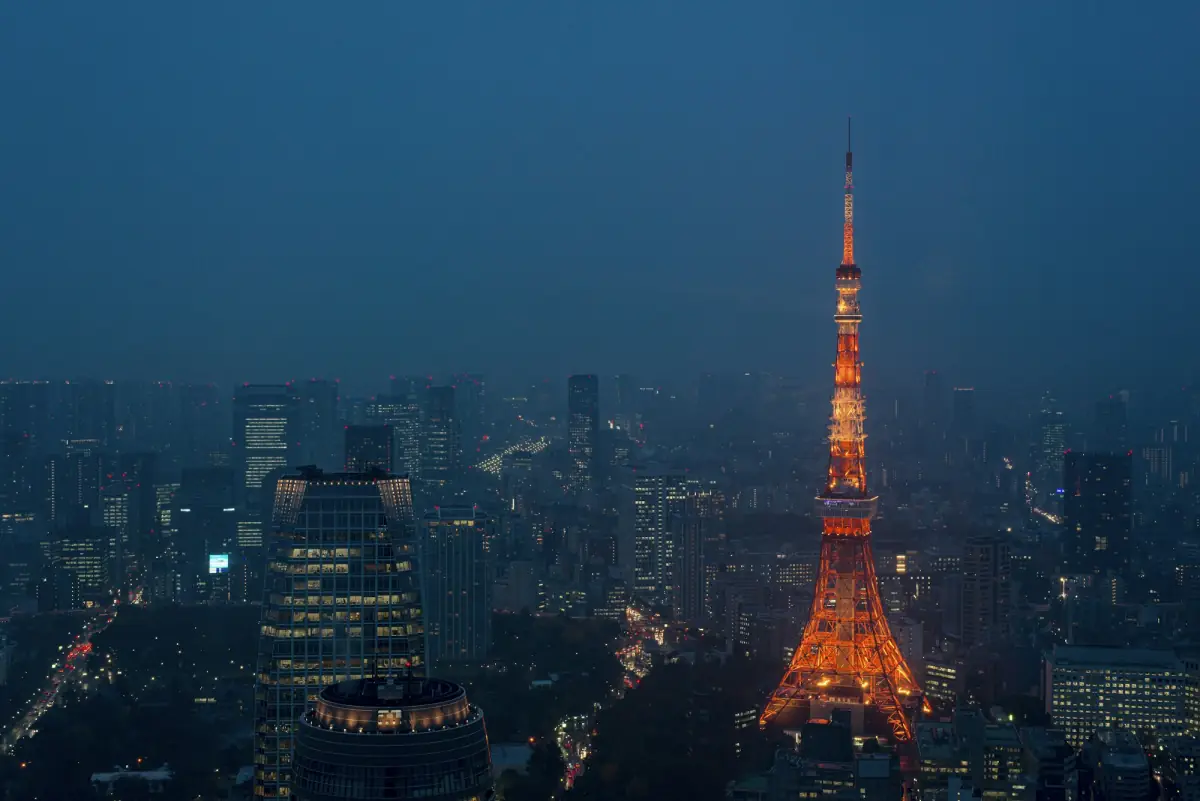 Tokyo Tower glowing orange above the dark blue city at dusk.