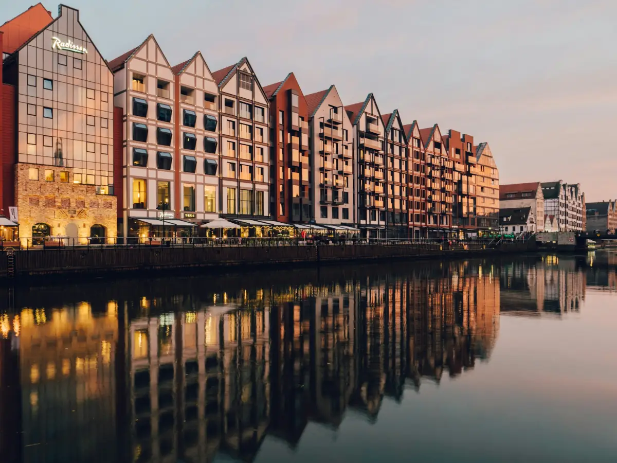 Gdansk's rebuilt granary buildings reflected in the Motlawa river at dusk.