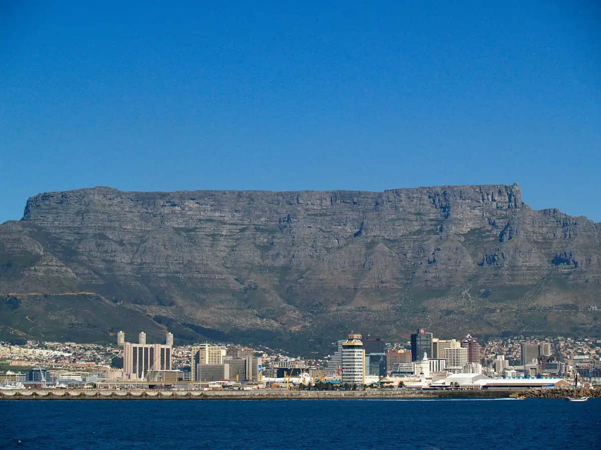 Table Mountain rising behind the Cape Town waterfront under a blue sky.