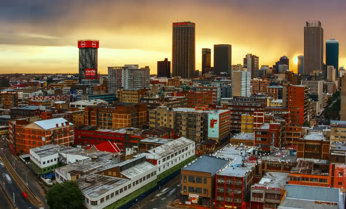 The Johannesburg skyline under a golden evening sky.